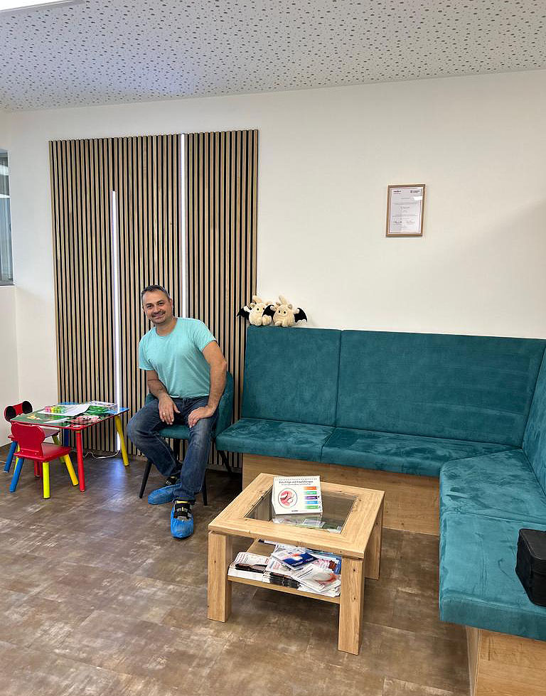 Wartezimmer mit petrolfarbener Sitzbank und Kinderecke